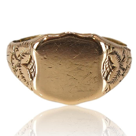 Gold ring with intricate design on a white background