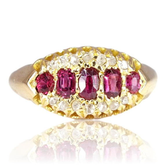 Gold ring with red gemstones on a white background