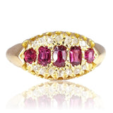 Gold ring with red gemstones on a white background