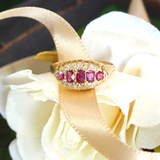 Gold ring with red gemstones on a white flower