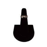 Ring on a black velvet stand against a white background
