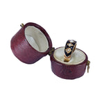 Open purple jewelry box with a ring inside on a white background