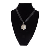 Necklace with a sparkling pendant on a black velvet stand against a white background