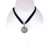 Necklace with a black ribbon and decorative pendant on a mannequin against a white background
