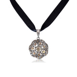 Necklace with a sparkling pendant on a black ribbon against a white background