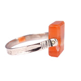 rose gold ring with a rectangular orange stone on a white background