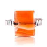 Ring with a rectangular orange stone on a white background