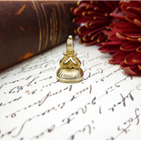 Gold stamp on an old document with a red flower in the background