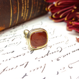 Decorative seal with a red stone on an old letter with visible handwriting