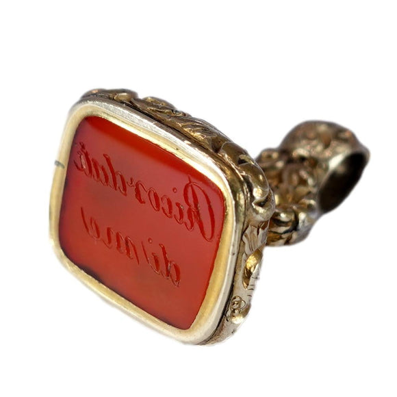 Gold pendant with red stone on a white background