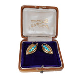 Pair of gold earrings with turquoise stones in a jewelry box