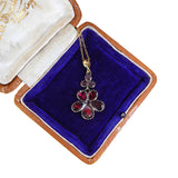Jewelry box with a pendant featuring red gemstones on a white background