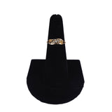 Gold ring with diamonds on a black velvet stand against a white background
