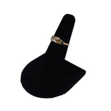 Gold ring with a diamond on a black velvet stand against a white background