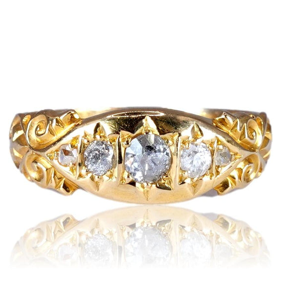 Gold ring with diamond accents on a white background