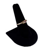 Silver ring with a gemstone on a black ring stand against a white background