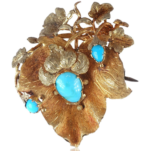 Gold brooch with turquoise stones on a white background