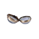 Open silver locket with a white interior on a white background