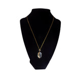 Necklace with a pendant on a black mannequin bust against a white background