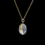 Necklace with a gold chain and pendant featuring a clear stone on a black background