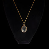 Gold necklace with a pendant on a black background