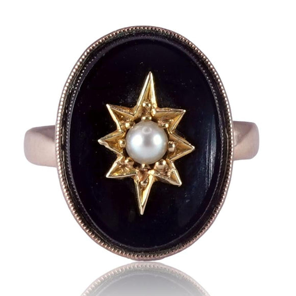 Ring with star design and pearl center on black background