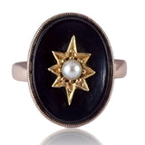 Ring with star design and pearl center on black background