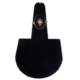 Ring on a black velvet stand against a white background