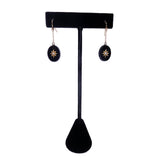 Black earring stand with two star-shaped earrings on a white background