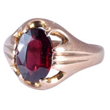 Gold ring with a red gemstone on a white background