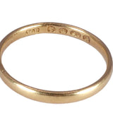 Gold ring with visible hallmarking on a white background