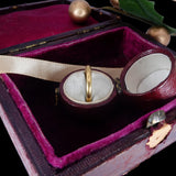 Gold ring in a jewelry box with a purple interior