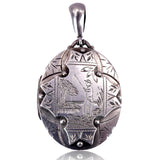Silver pendant with intricate designs on a white background