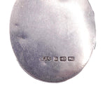 Silver object with engraved text on a white background