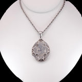 Silver pendant necklace on a mannequin bust against a white background