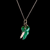 Green leaf-shaped pendant with a smaller white feather pendant on a chain against a black background