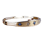 Gold bracelet with star-shaped gemstones on a white background