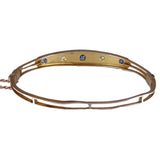 Gold bracelet with embedded stones on a white background