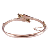 Rose gold bracelet with gold beads on a white background