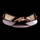 Gold ring with a decorative setting in an open jewelry box on a black background