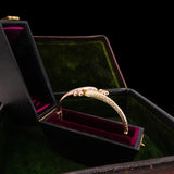 Gold bracelet in an open jewelry box with a dark background