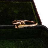 Gold ring with a unique design on a green velvet surface