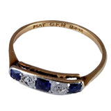 Gold ring with sapphire and diamond stones on a white background