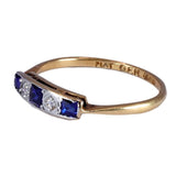 Gold ring with blue gemstones on a white background