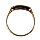 Gold ring with a dark gemstone on a white background