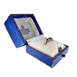 Gold ring with a blue stone in an open blue jewelry box on a white background