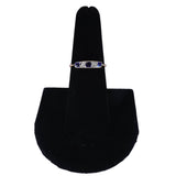 Ring on a black display stand against a white background