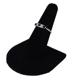 Ring on a black velvet stand against a white background