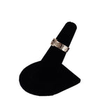 Silver ring on a black stand against a white background