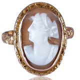 Gold ring with a cameo design on a white background